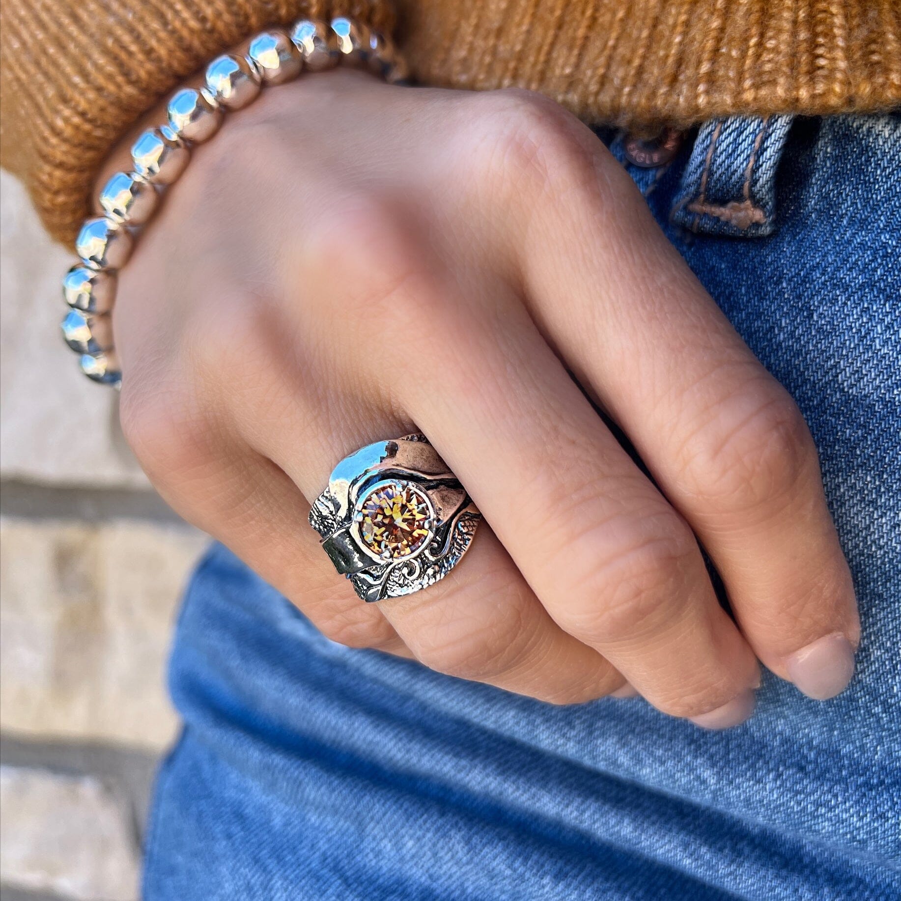 sterling silver ring with unique band, featuring a round prong set golden CZ stone