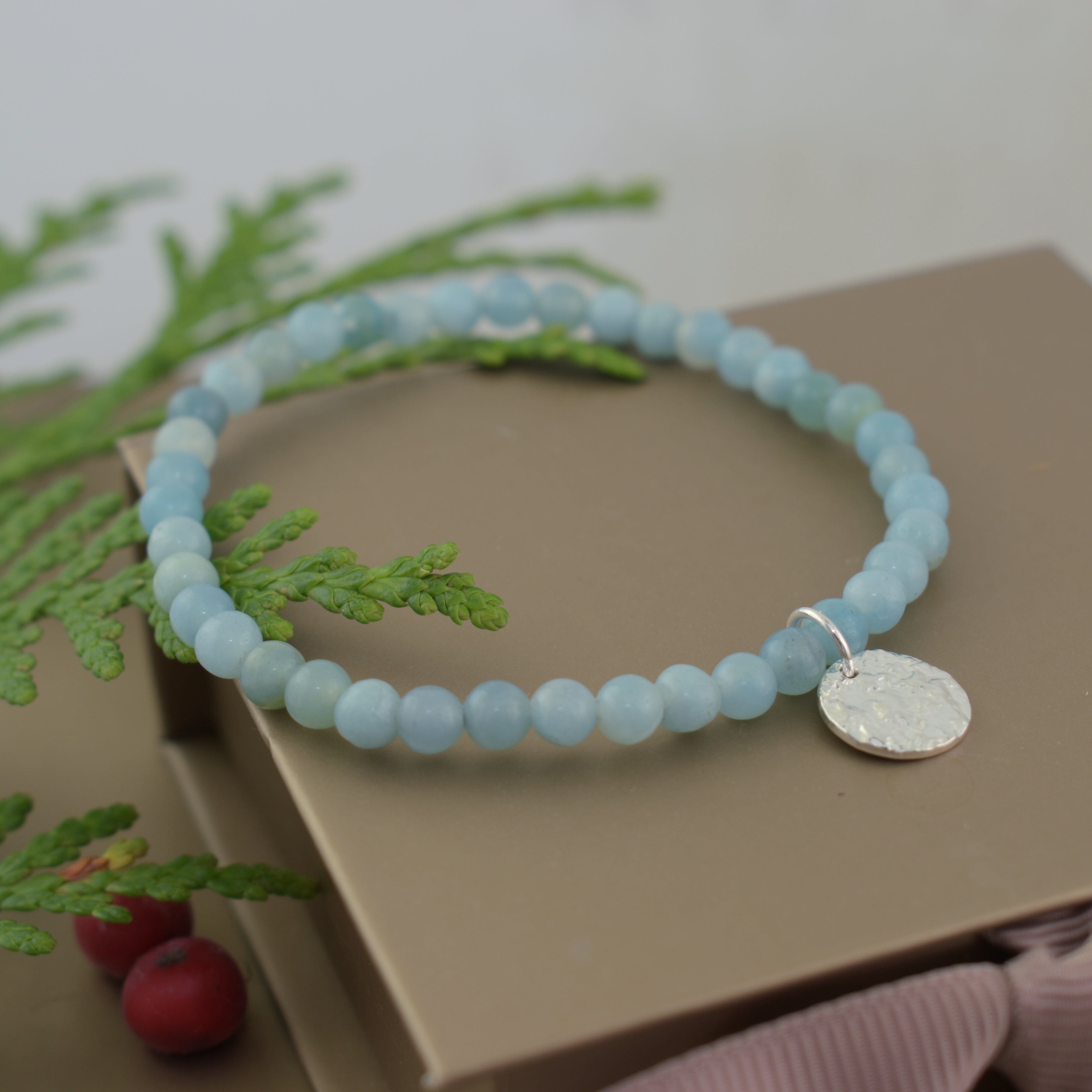 amazonite stretch style bracelet with a round, silver hammered charm