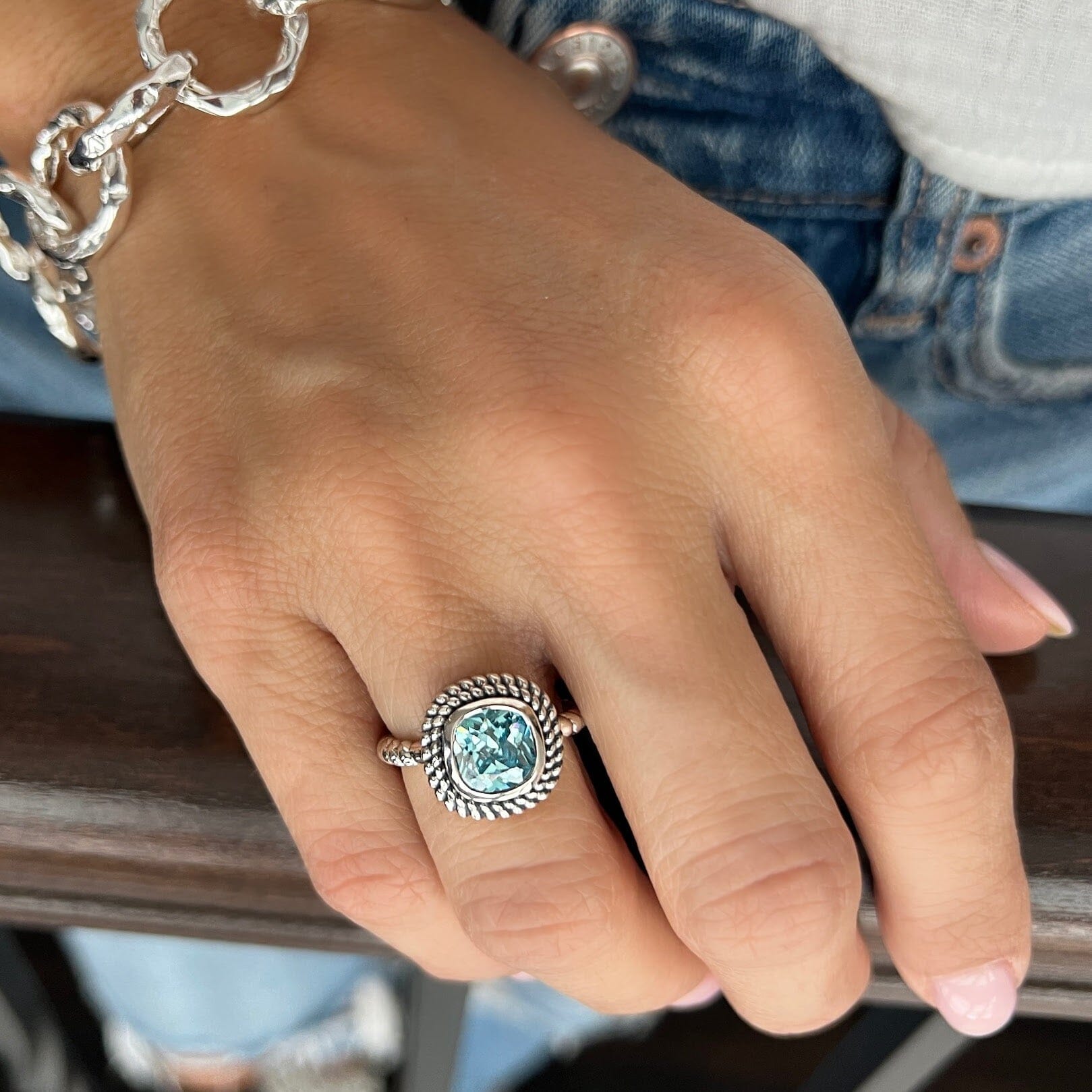 cushion cut blue topaz stone set in a silver double-beaded bezel