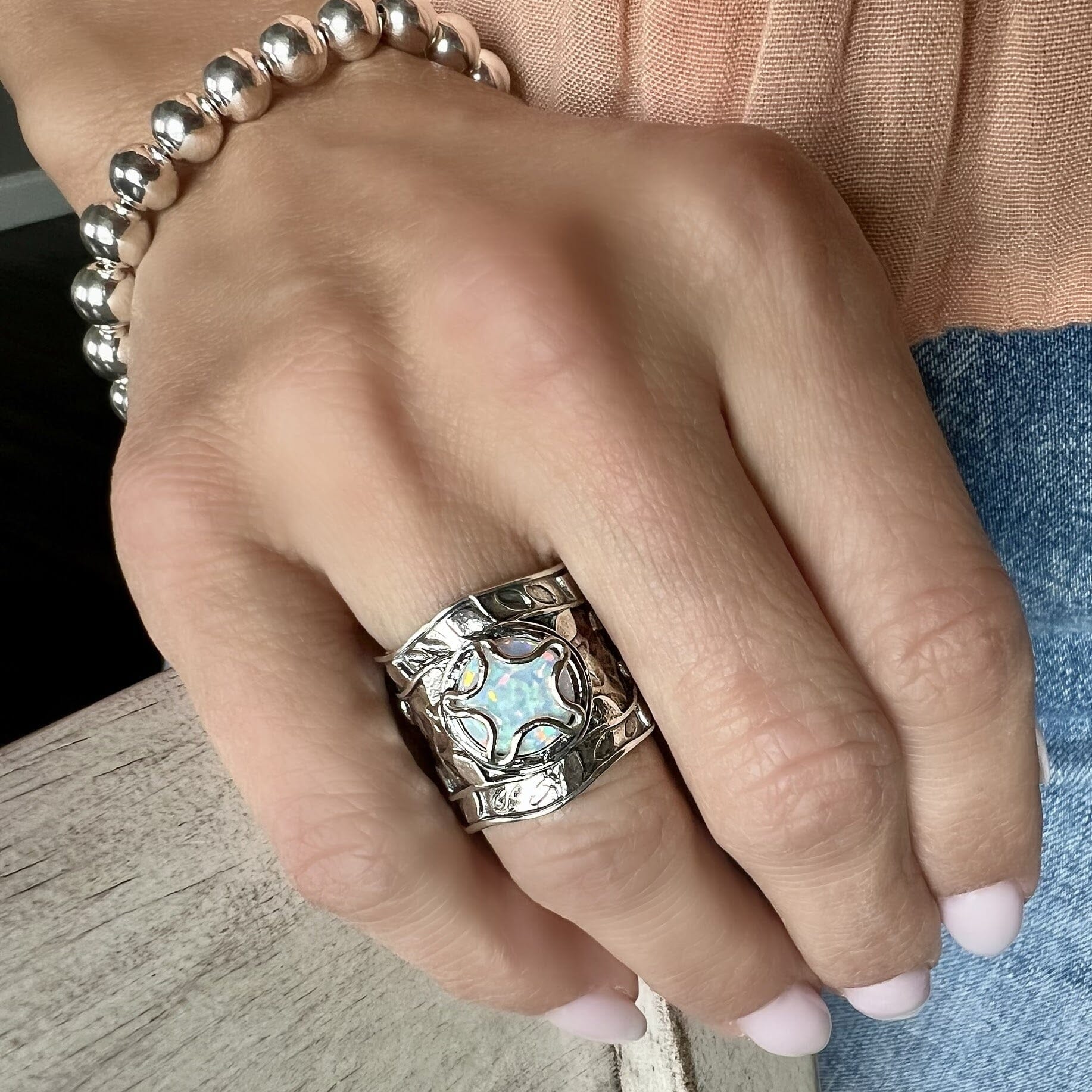 large sterling silver ring featuring a star shaped bezel with a reconstructed opal stone