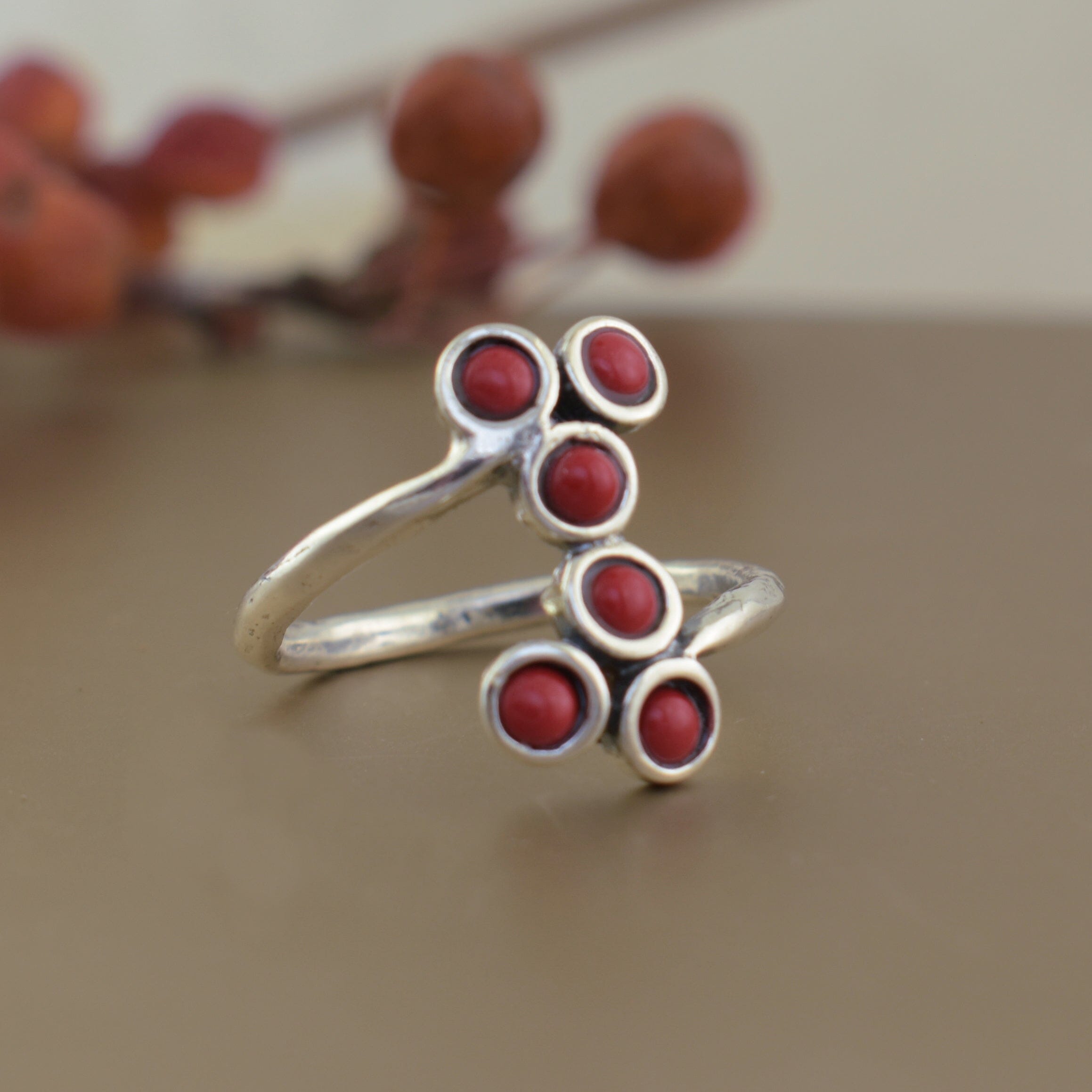 .925 sterling silver ring featuring round red coral colored stones