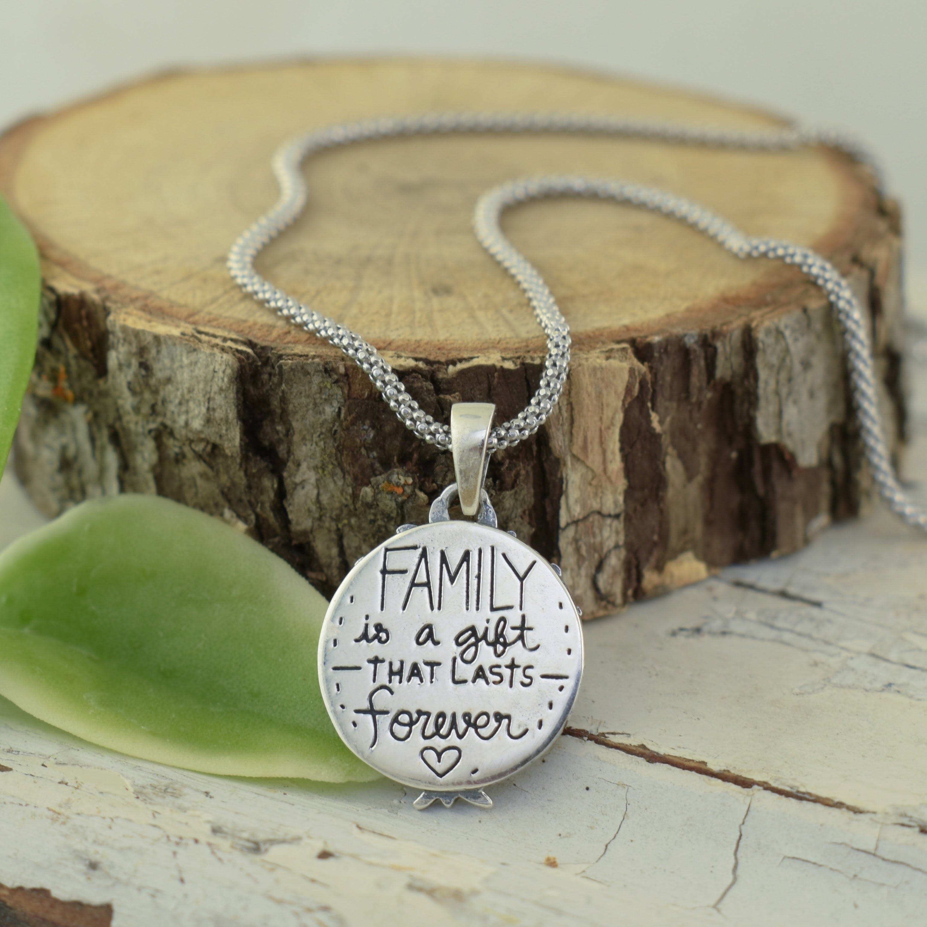 Family tree necklace in sterling silver featuring engraved message "Family is a gift that lasts forever."