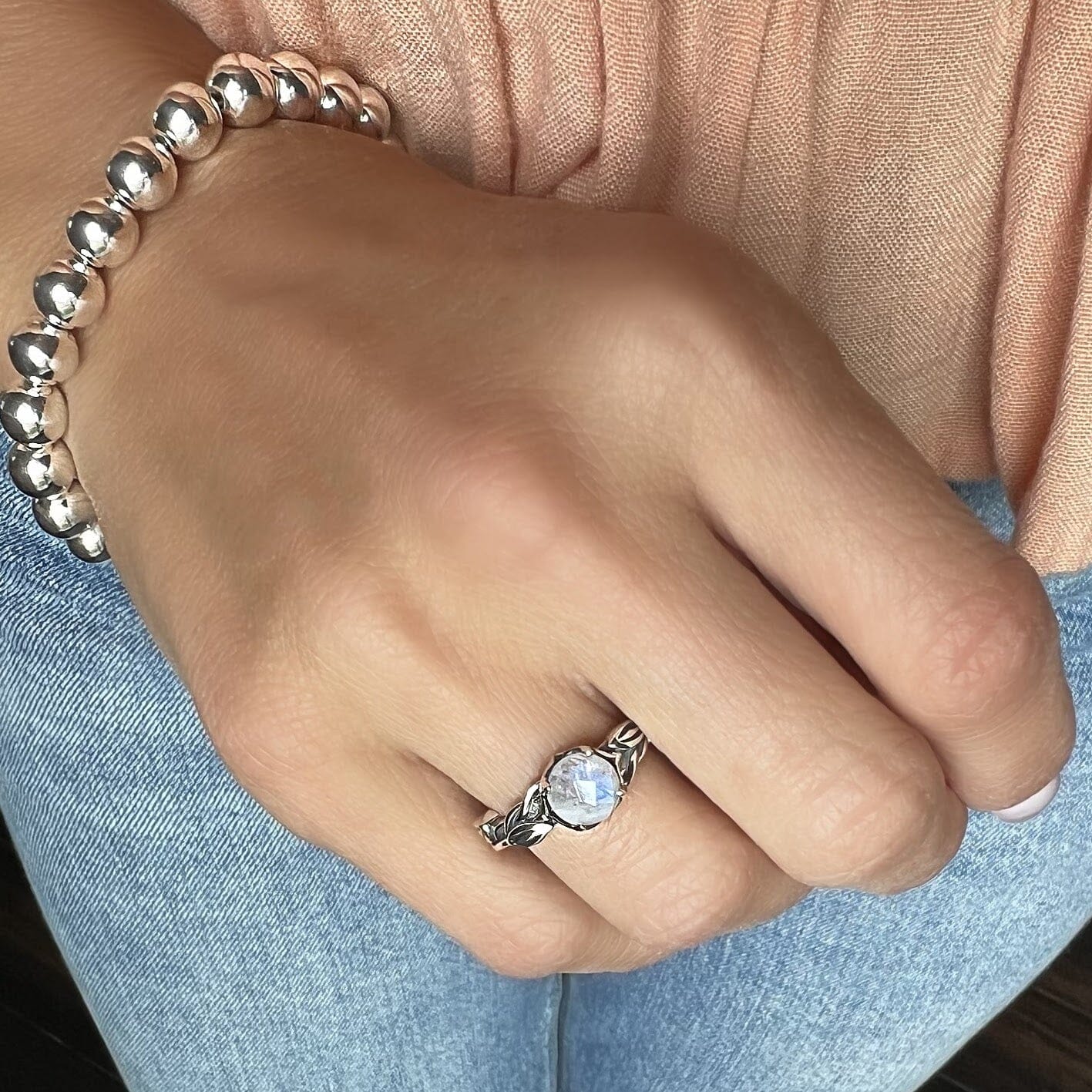 sterling silver vine designed ring with an iridescent center stone