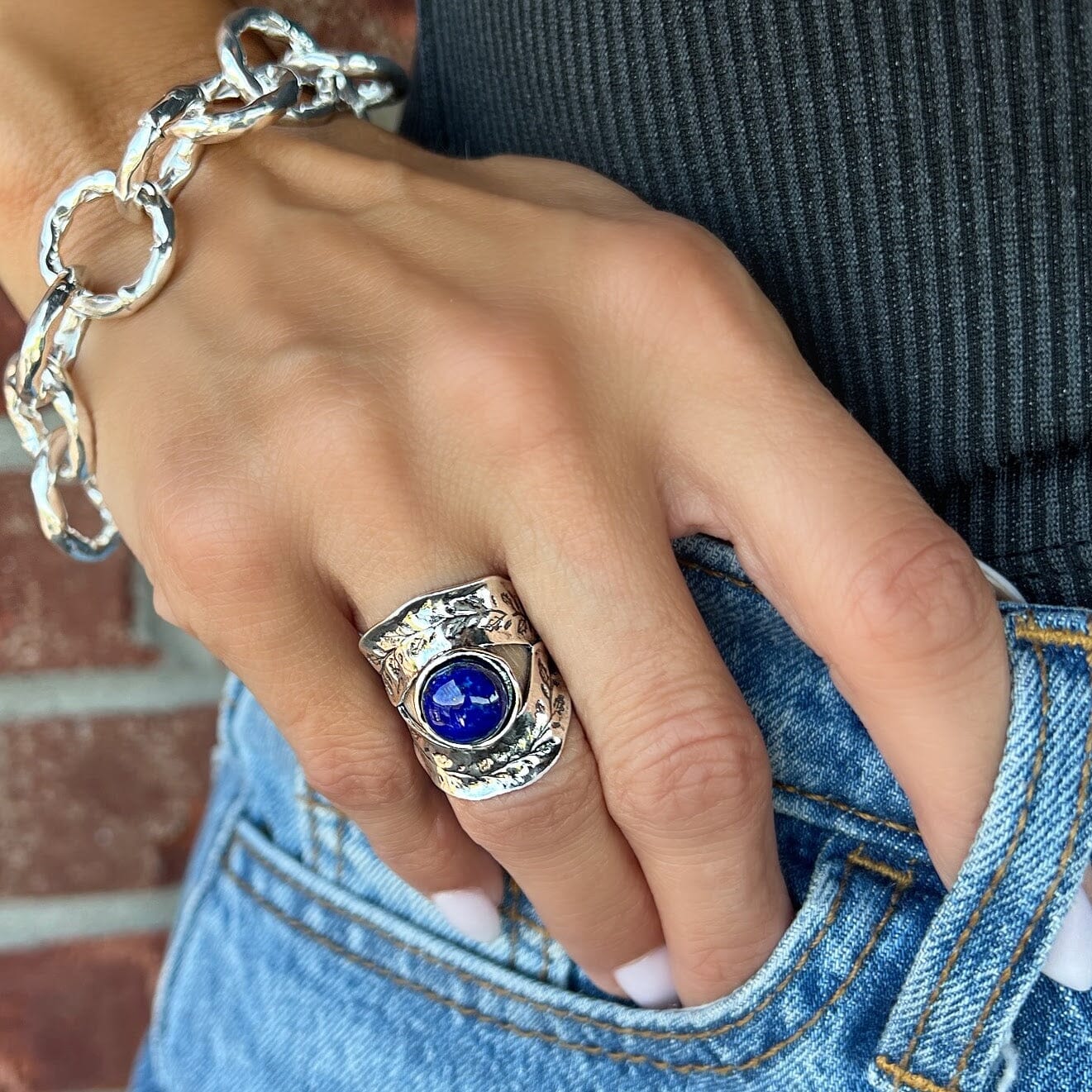 chunky silver ring featuring filigree and a lapis center stone