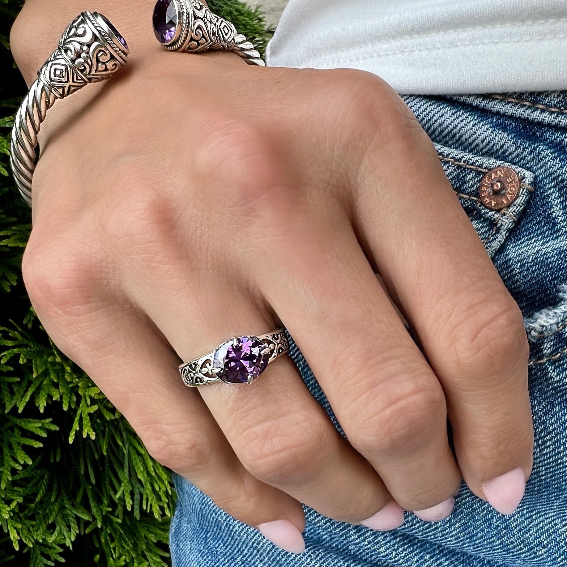 silver band with cut out heart-shaped swirls and prong-set amethyst cubic zirconia