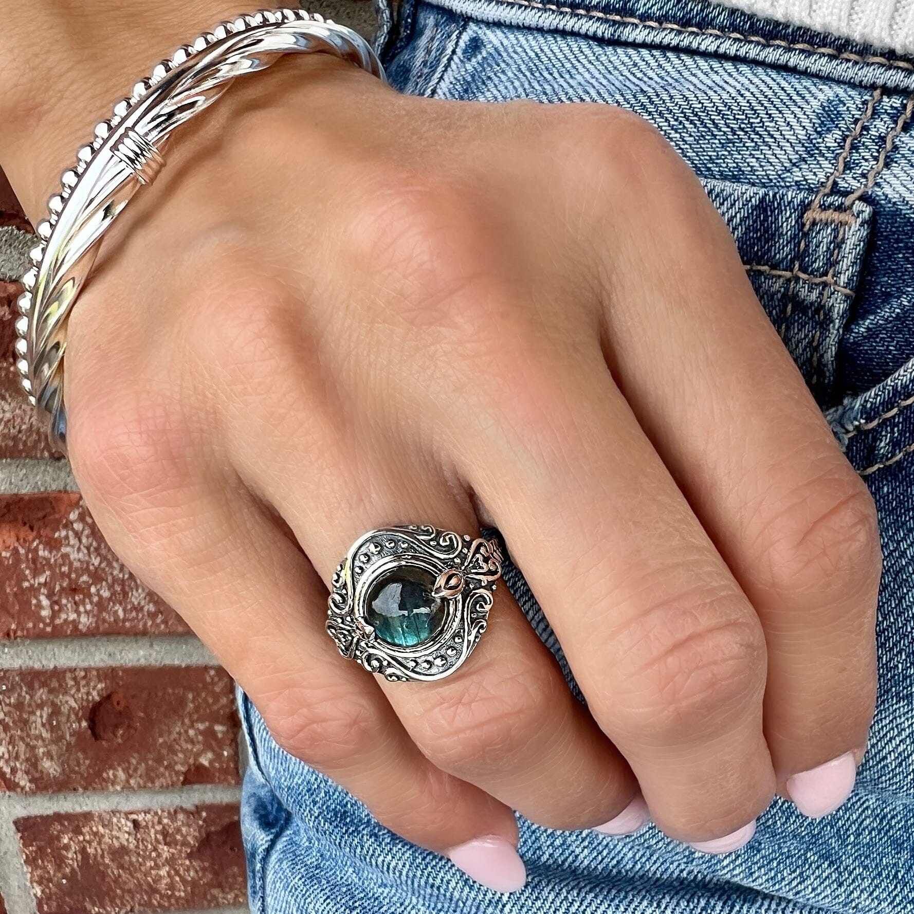 silver decorated ring featuring a labradorite center