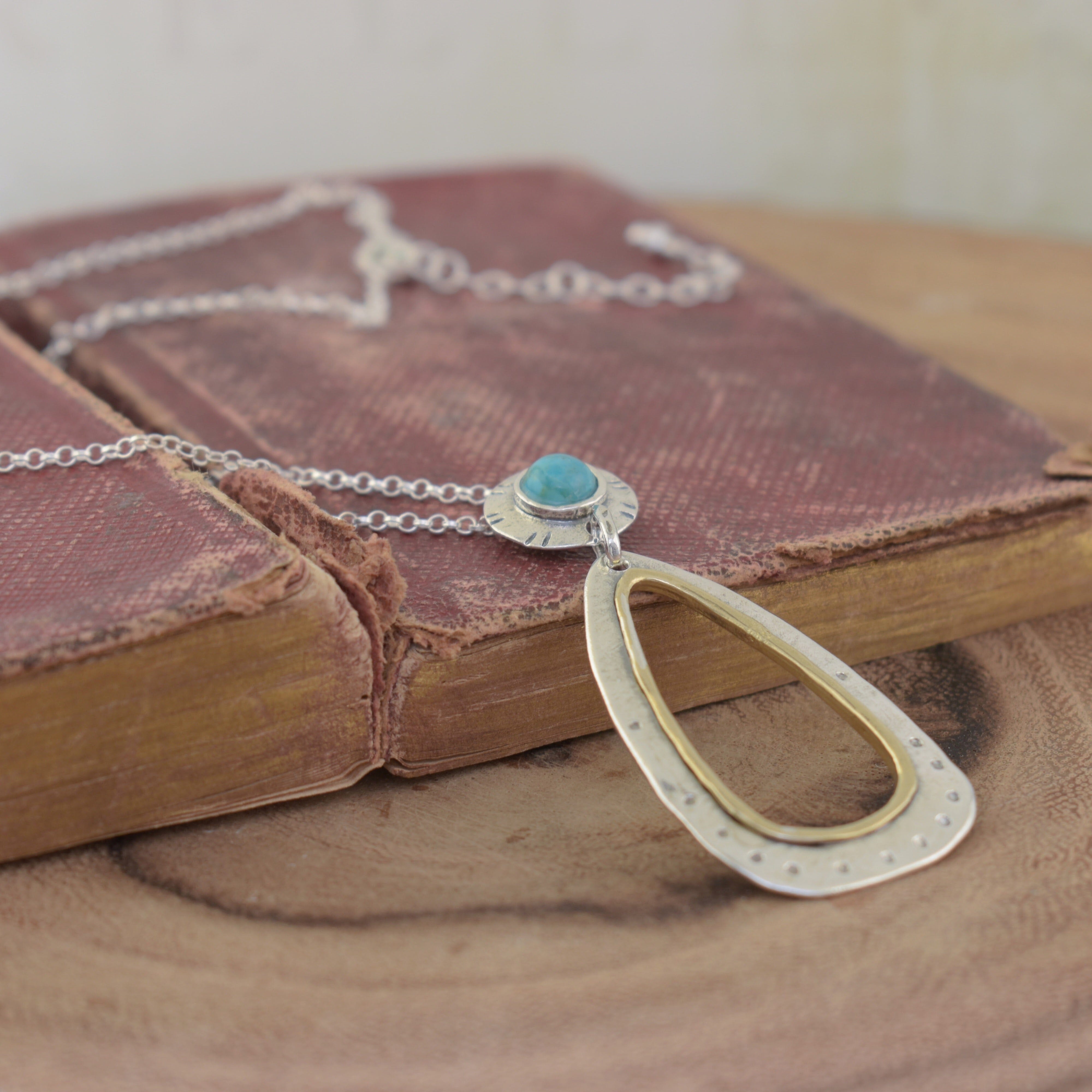 Designer sterling silver and brass necklace featuring turquoise stone