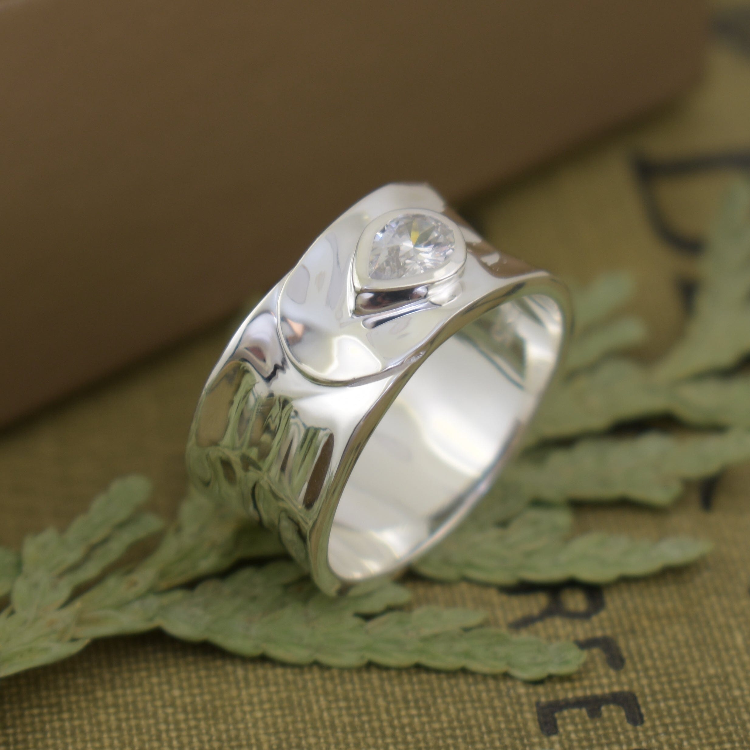 wrap design silver ring with a clear, pear shaped cz stone