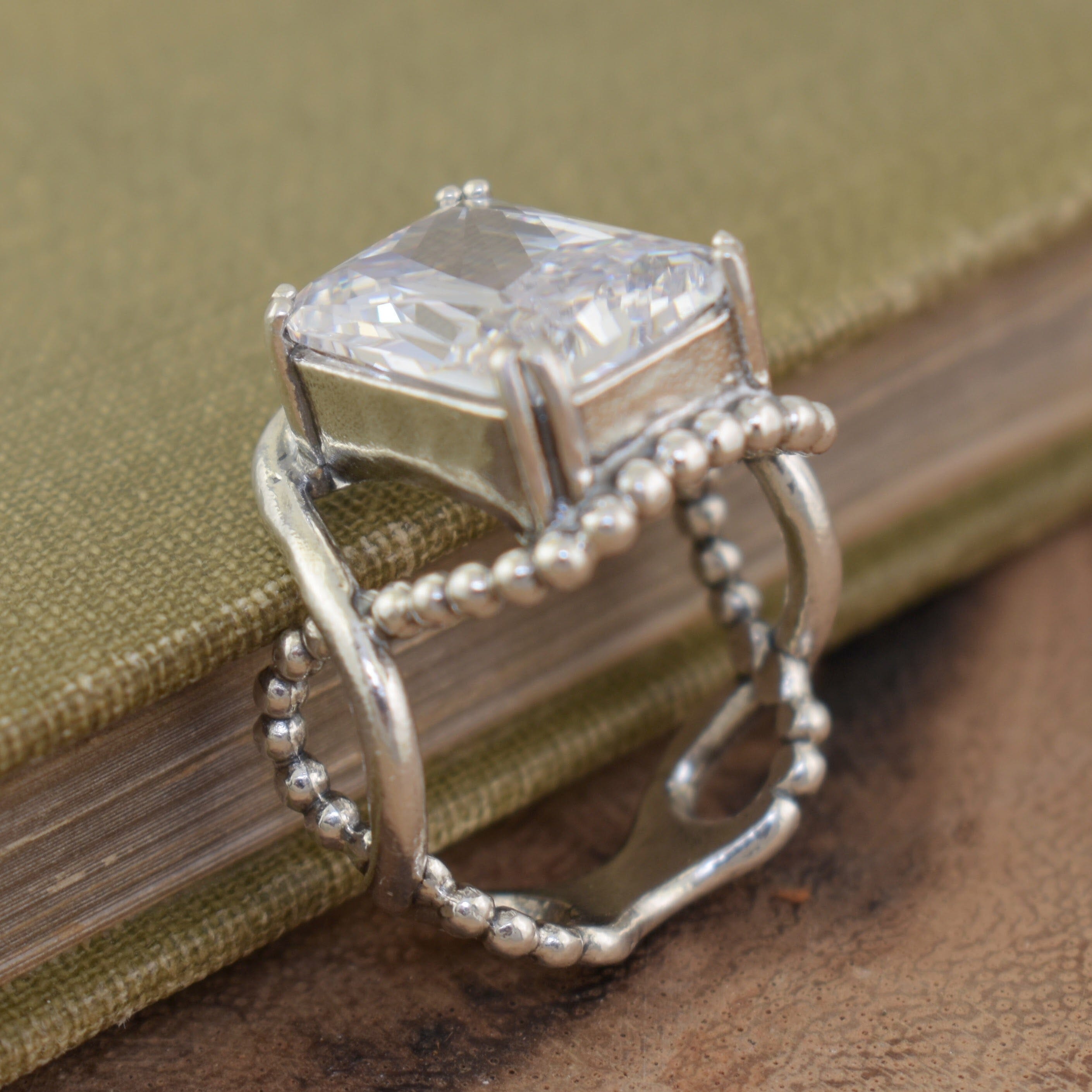 Clear emerald cut CZ stone set in beaded and plain twisted band