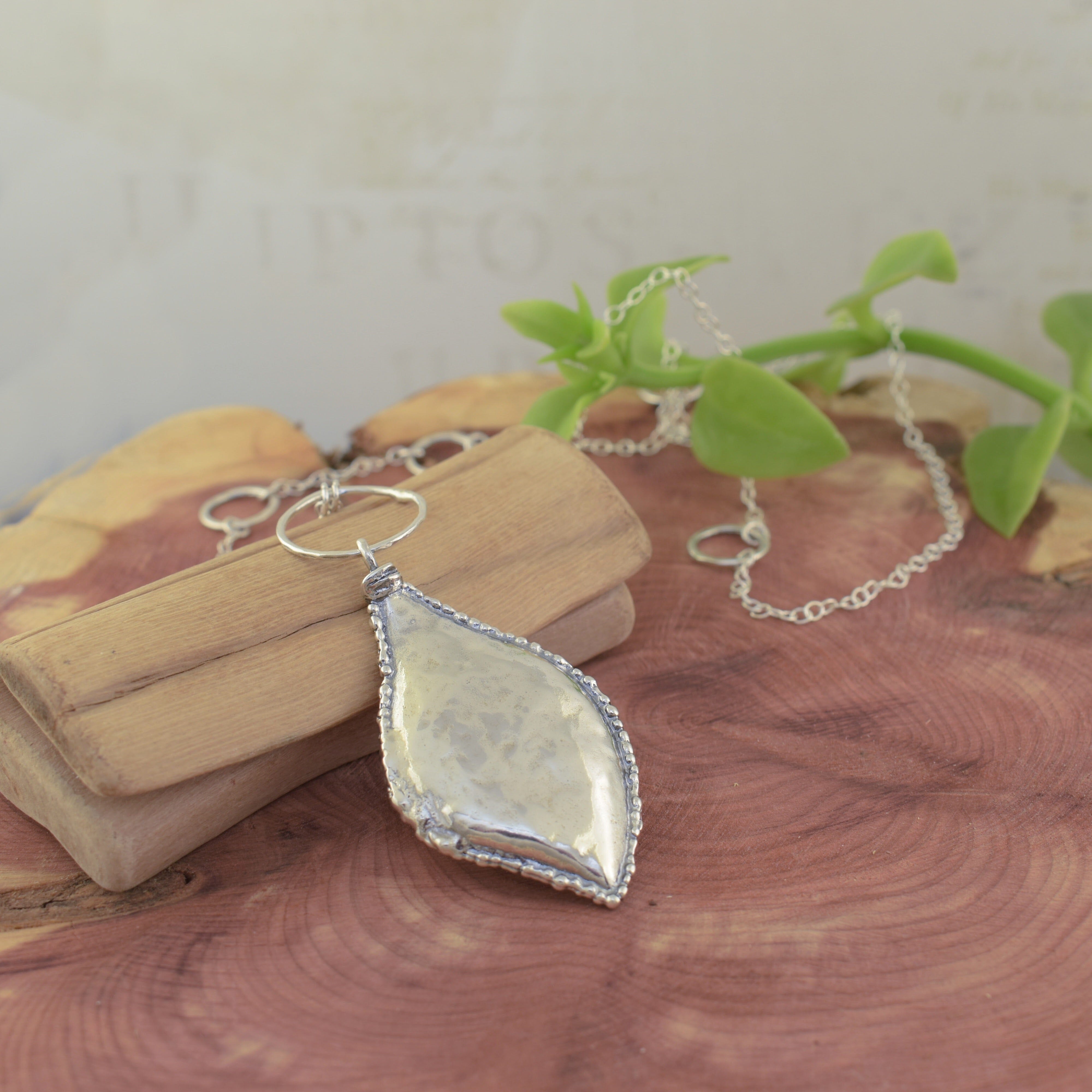 chic, nature-inspired leaf necklace in sterling silver with circular pendants in the chain