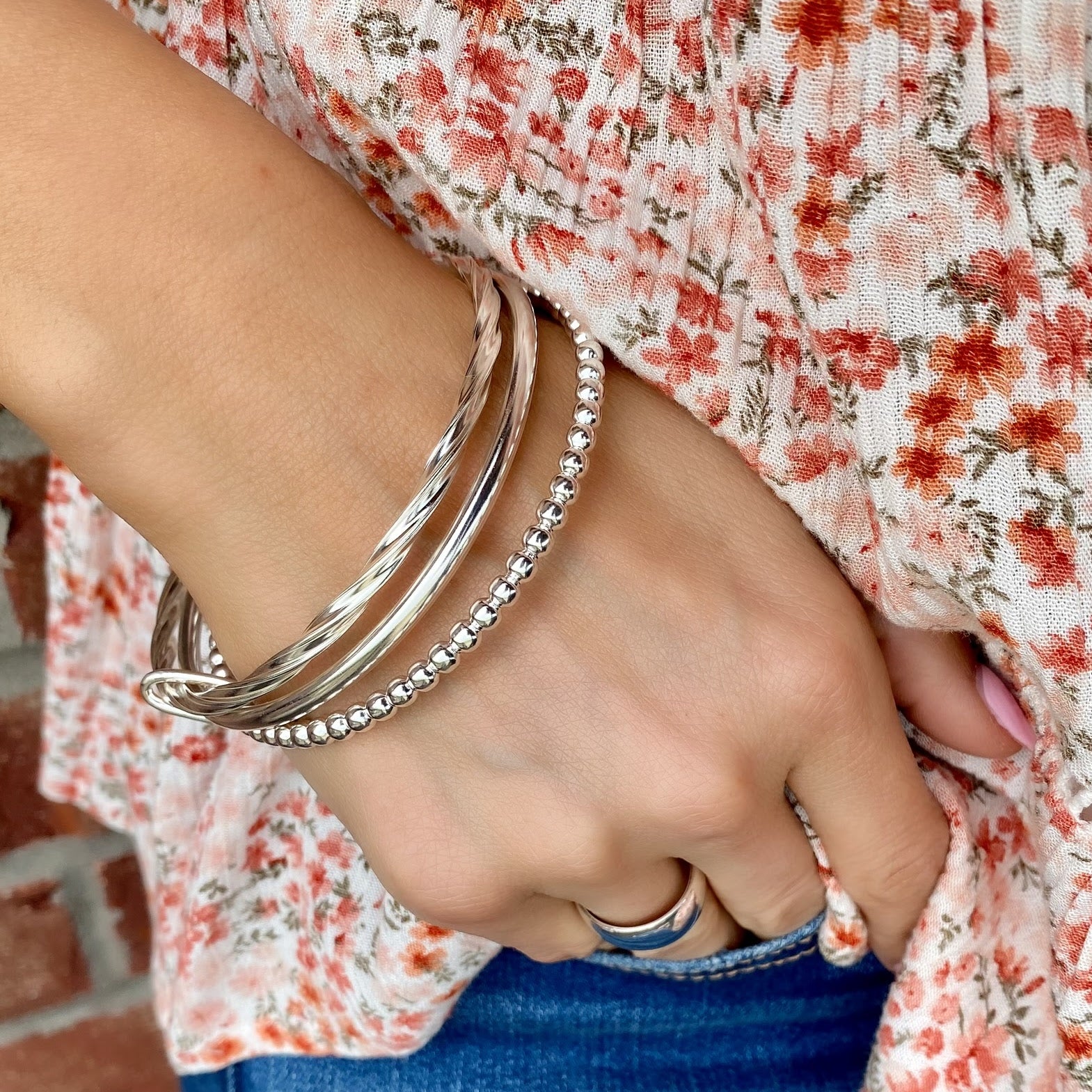 trio of bangles featuring twists, beads, and a high polish finish